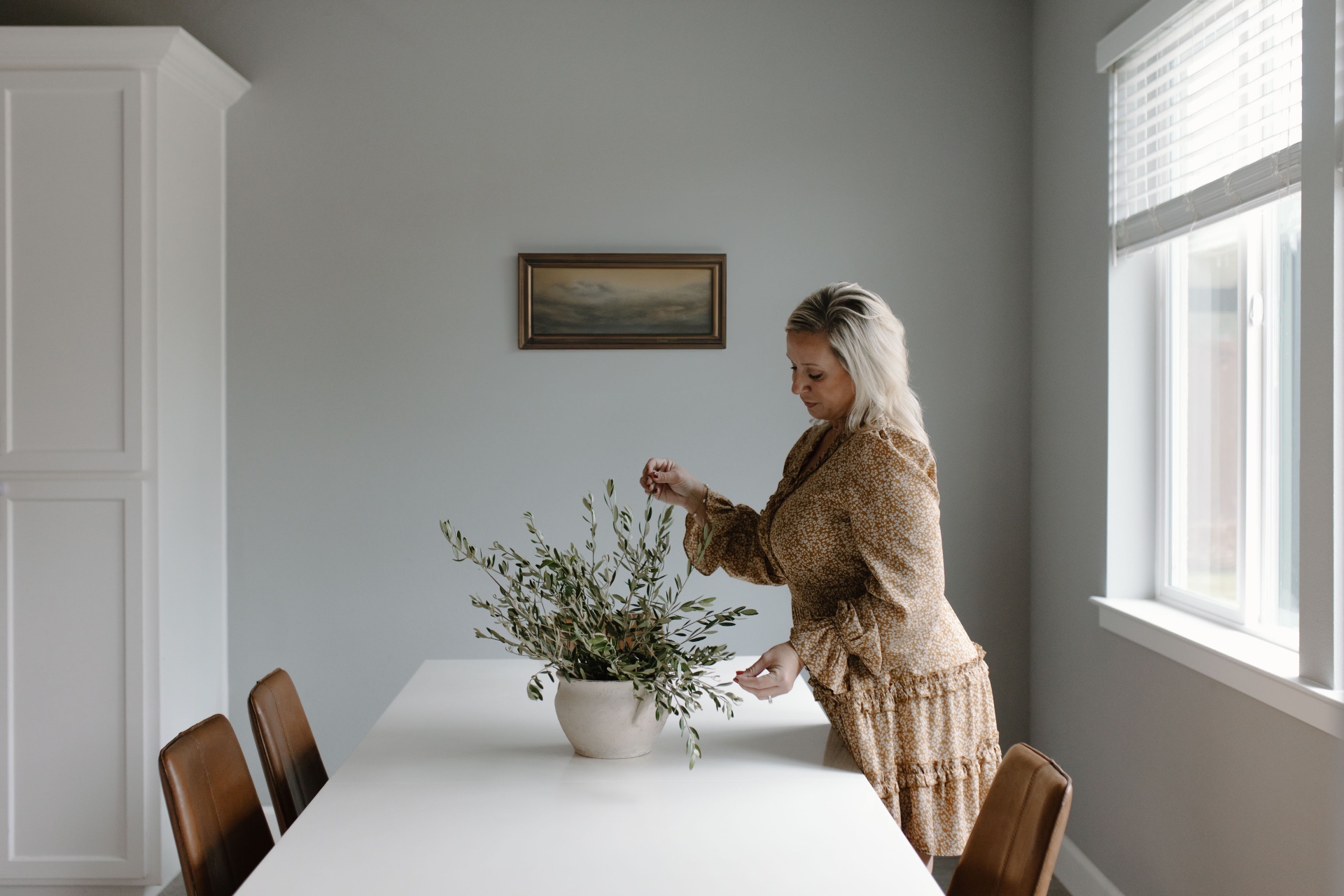 Cassie arranging olive branches in a quiet interior